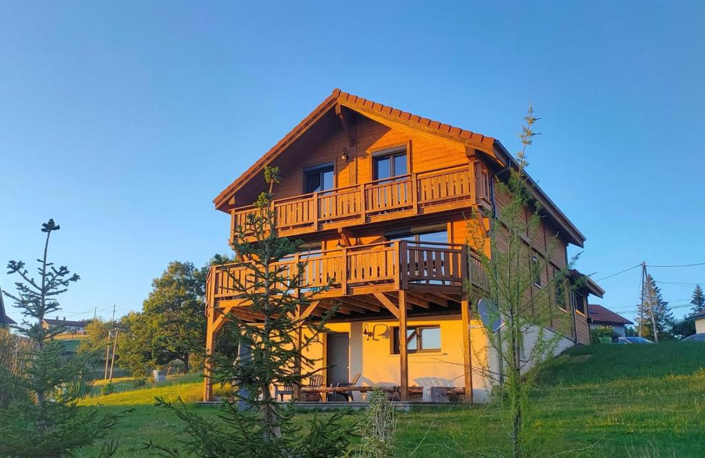 a large wooden house with a balcony on a hill at Chalet 360 l Essenti Aile, Gerardmer La Mauselaine in Gérardmer
