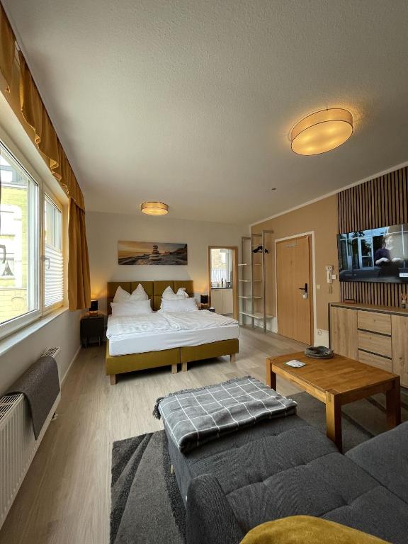 a bedroom with a bed and a living room with a couch at TuS-FeWo#04 - Serviced & Executive Apartments in Mönchengladbach