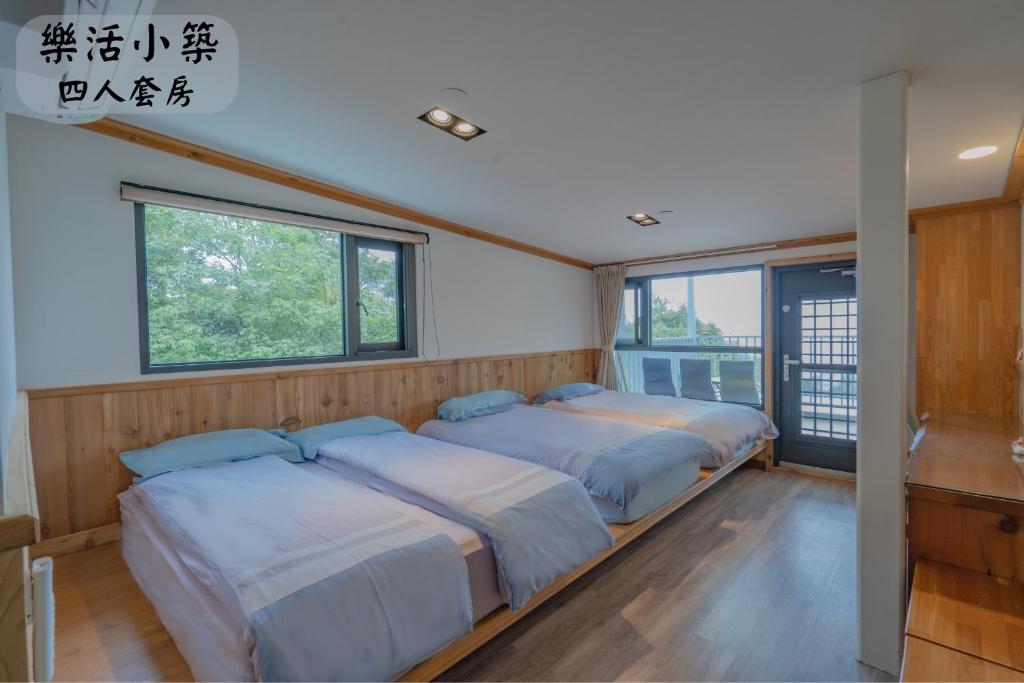 2 Betten in einem Zimmer mit 2 Fenstern in der Unterkunft 江山樂活Lohas in Puli
