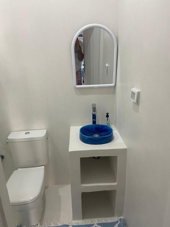 a white bathroom with a toilet and a mirror at RESIDENCE DAR YASMINa in Mezraya