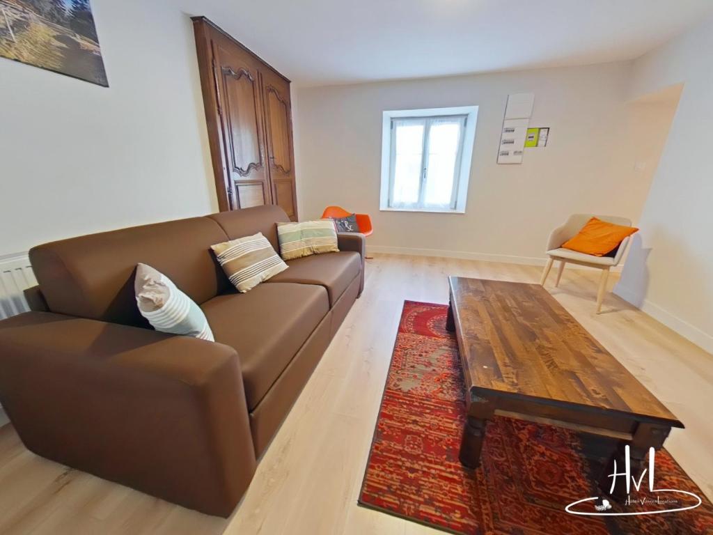 a living room with a brown couch and a coffee table at Maison Bedel, La Schlucht Gerardmer in Gérardmer