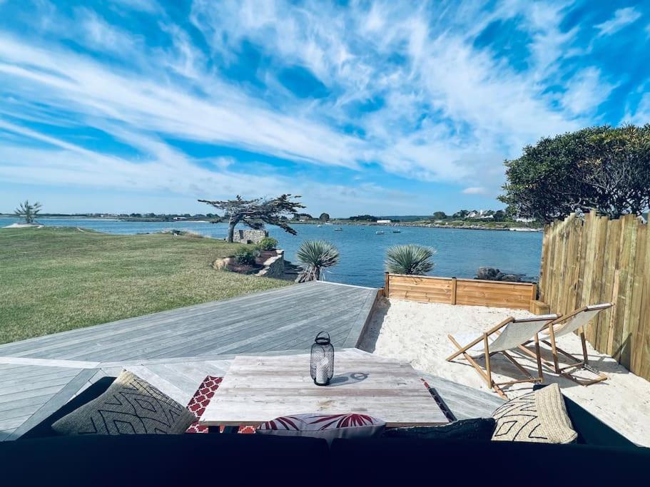 - une table avec une bouteille à côté de l'eau dans l'établissement Cottage les pieds dans l'eau, à Montfarville