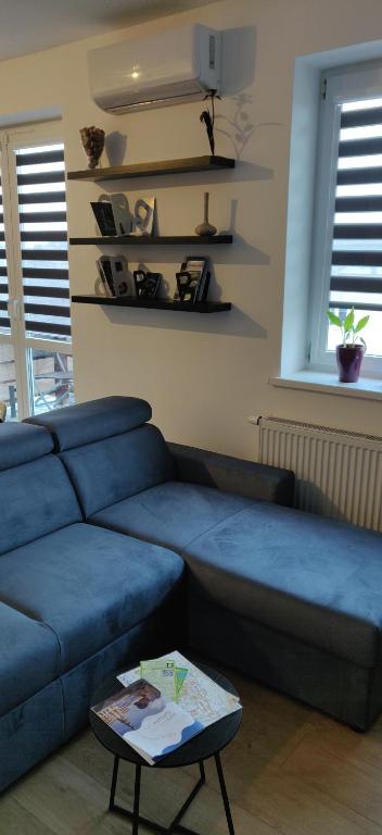 salon z niebieską kanapą i stołem w obiekcie Apartament Turysty Zamczysko w mieście Zamość
