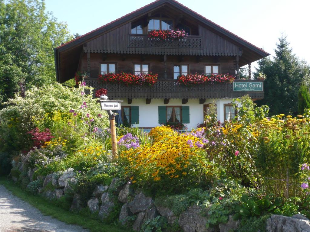 a building with a bunch of flowers in front of it at Landhaus Caesar - Hotel Garni in Bad Heilbrunn