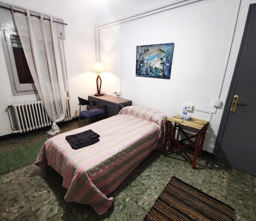 a bedroom with a bed and a table and a lamp at ArtStudio Double in Manresa