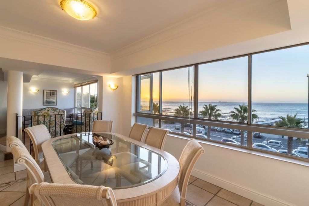 a dining room with a view of the ocean at Beachfront Seaview in Cape Town