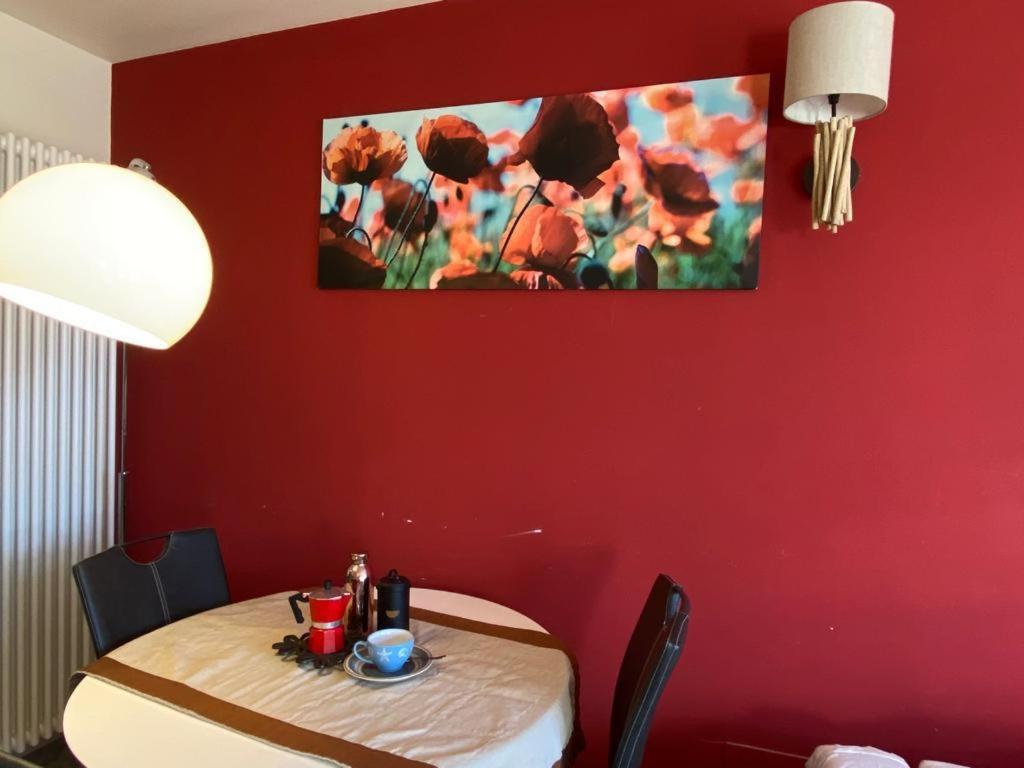 a table in a room with a red wall at macalu 1 in Prato Nevoso