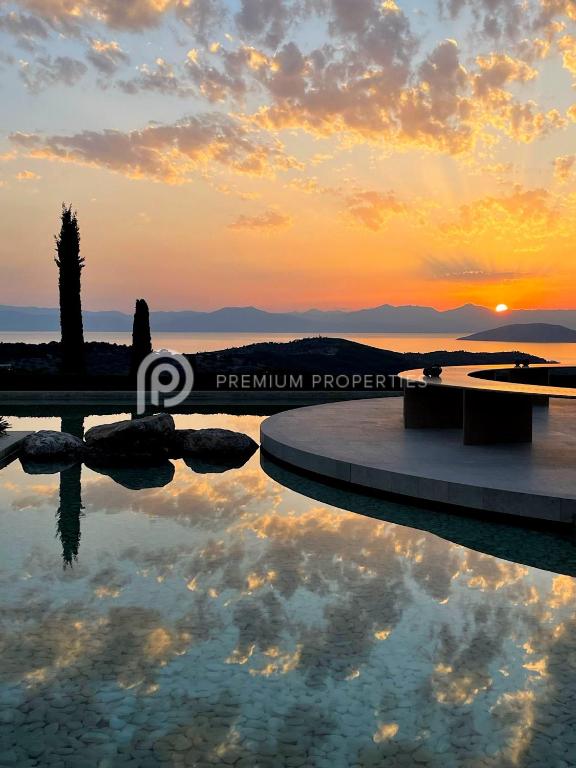 a swimming pool with a sunset in the background at Villa Tranquility - Walk to the Beach with Infinity Pool in Porto Heli