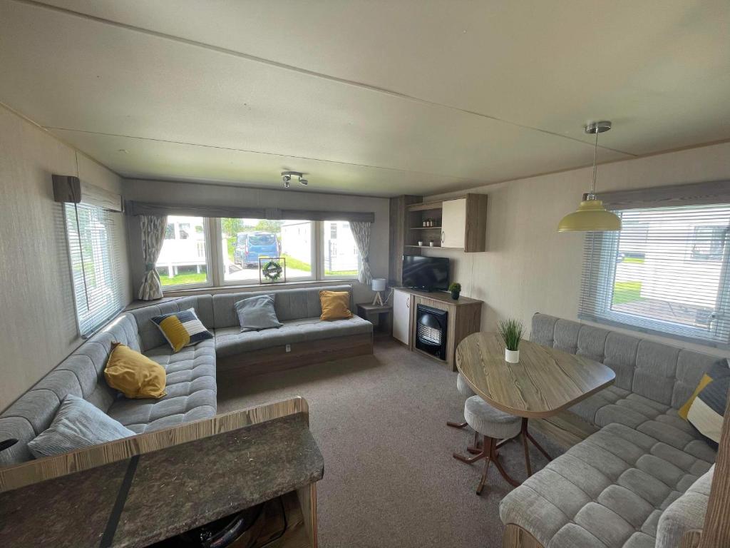 a living room with a couch and a table at Breaks on the Lakes in Tattershall