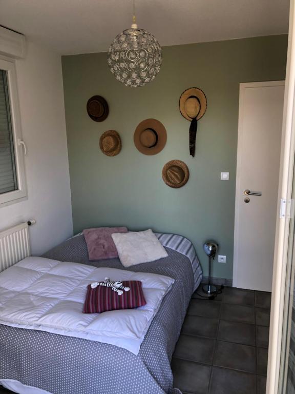 een slaapkamer met een bed en een kroonluchter bij Coquet appartement in Turckheim