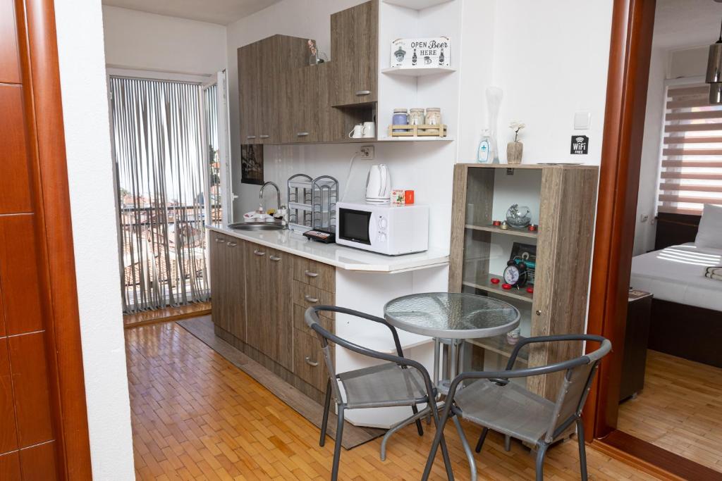 kuchnia ze stołem, krzesłami i kuchenką mikrofalową w obiekcie ON TOP Central Villa w mieście Kruszewo