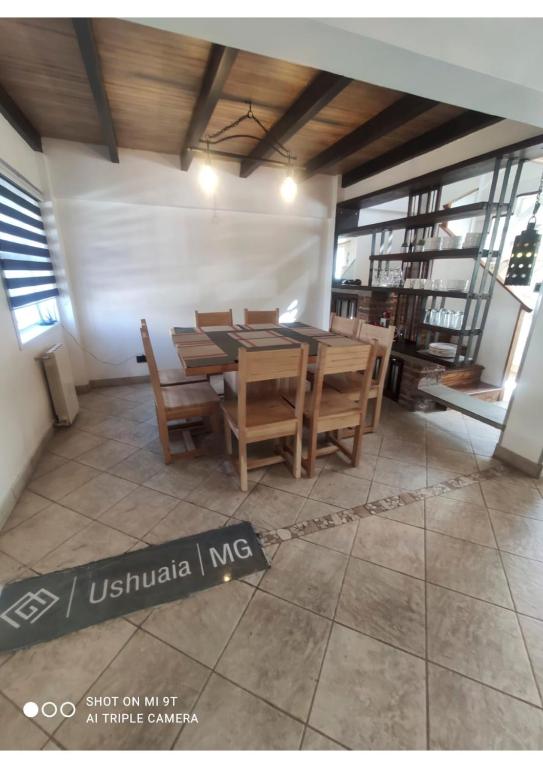 a dining room with a wooden table and chairs at USHUAIA MG in Ushuaia