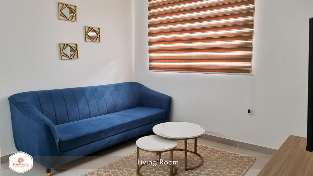 a blue couch in a living room with a table at StayMazing Manyata-1BHK Boutique AC Apartments -Couple Friendly in Bangalore