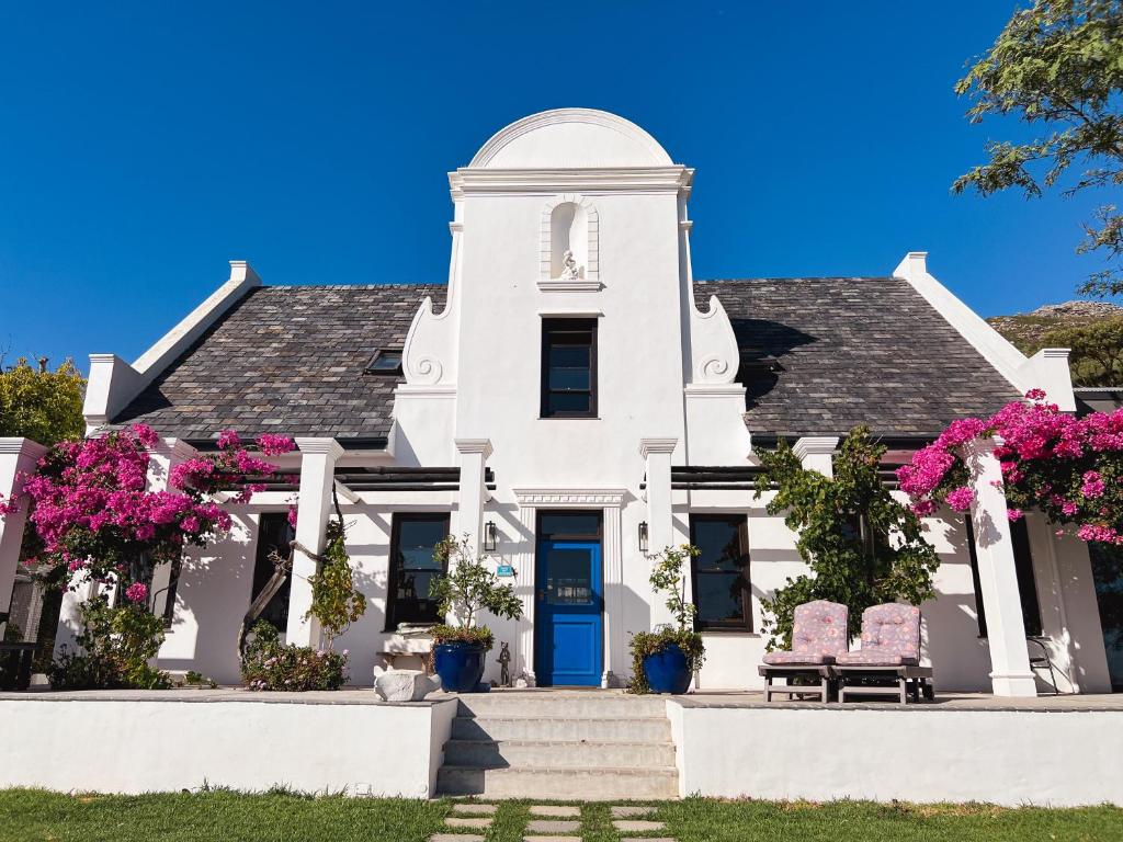 a white house with pink flowers in front of it at Chez ArtéKatz in Cape Town