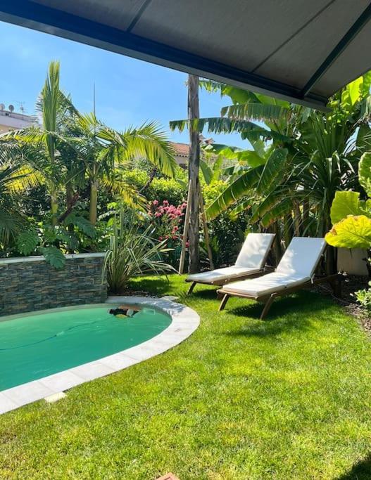 une cour avec deux chaises et une piscine dans l'établissement The Beach Dream Cagnes Sur Mer, à Cagnes-sur-Mer