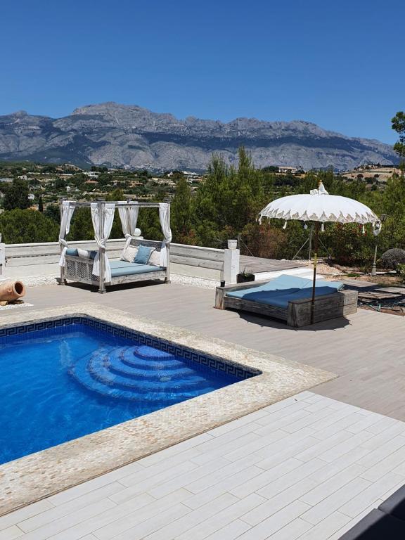 a swimming pool with a patio and an umbrella at elparaiso-altea Luxury Apartment "CIELO" ADULTS ONLY Bed & Borrel in Altea
