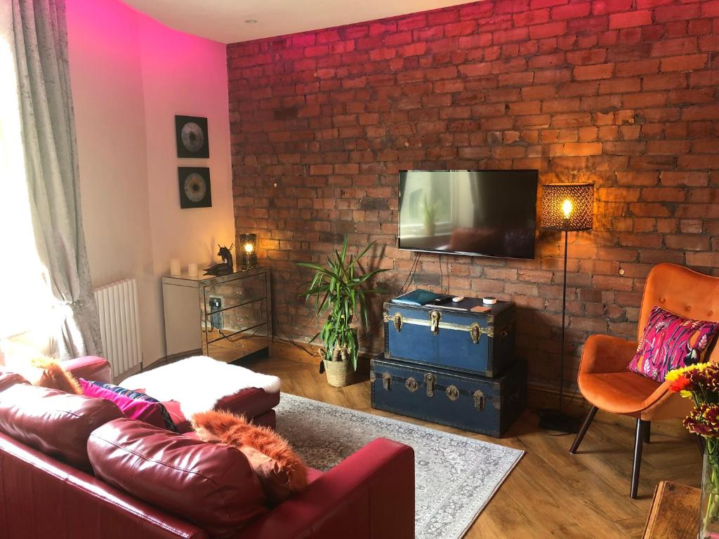 a living room with a couch and a brick wall at Top O’ Th’ House . Hebden Bridge in Hebden Bridge