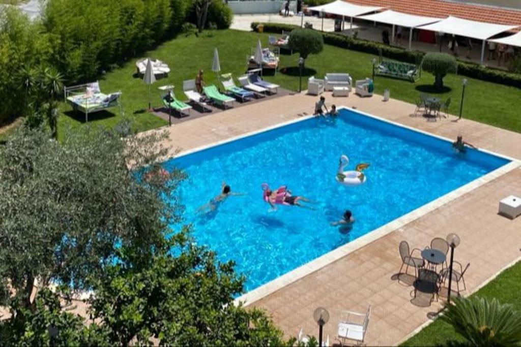 un gruppo di persone che nuotano in una piscina di Pompeii Garden House a Scafati