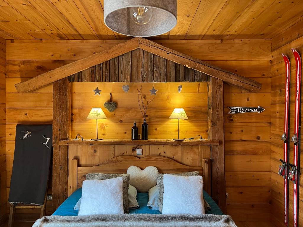 a bedroom with a bed in a wooden cabin at LAPRESKI, Appartement 4 étoiles, atmosphère chaleureuse entre Annecy et Aravis in Thônes