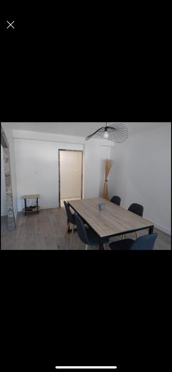 une salle à manger avec une table et des chaises en bois dans l'établissement Appartement T4 centre Tarbes, à Tarbes