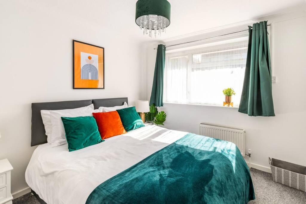 una camera da letto con un grande letto con cuscini verdi e arancioni di Ark on the Hill a Chatham