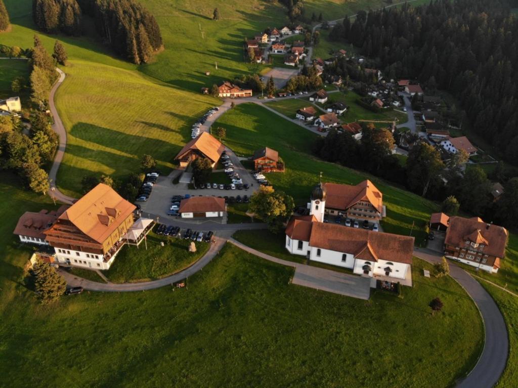 Luftblick auf ein kleines Dorf mit einer kurvenreichen Straße in der Unterkunft Hotel Kurhaus Heiligkreuz in Heiligkreuz