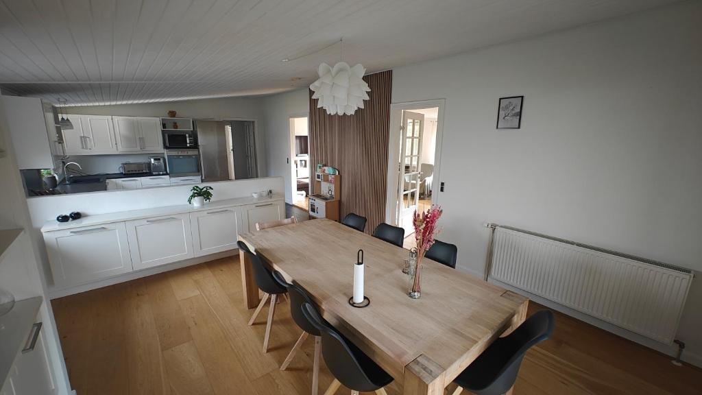 una cucina e una sala da pranzo con tavolo e sedie in legno di Apartment a Hovborg