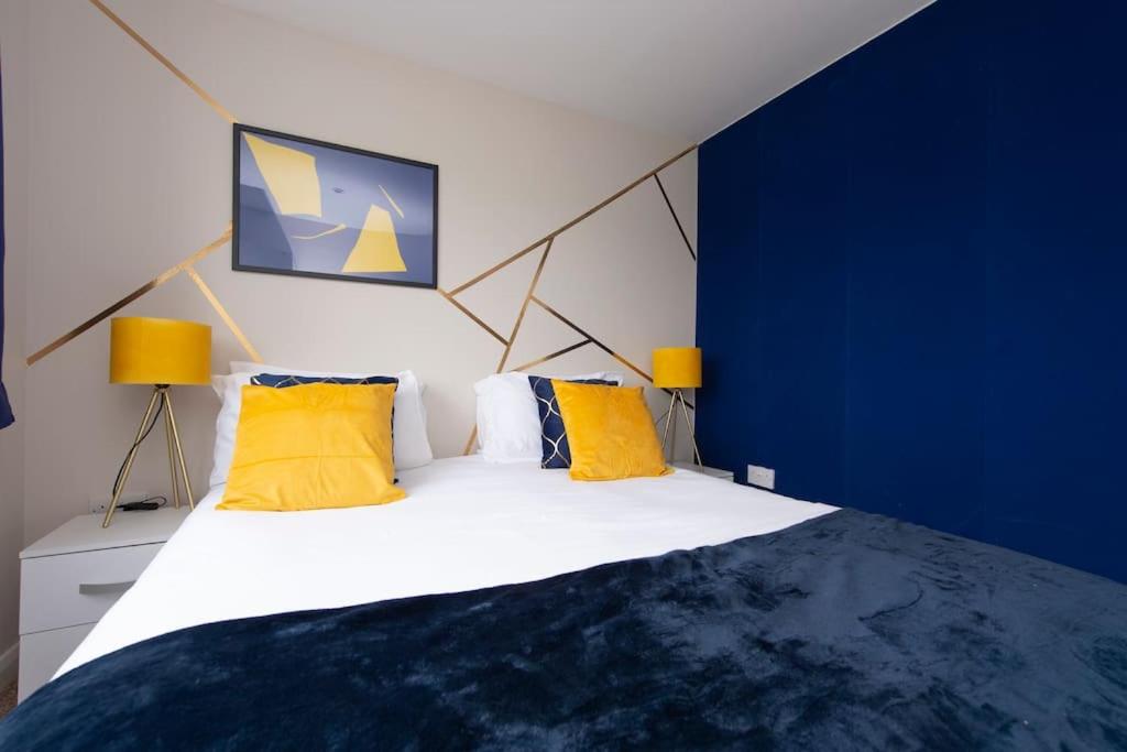 a bedroom with a large white bed with yellow pillows at The Shield in Chatham
