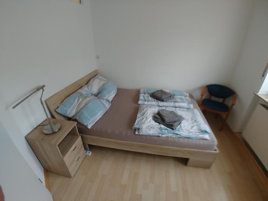 a bed in a room with a lamp and a night stand at Monteur- und Ferienwohnung Gemmer 63qm in Herold