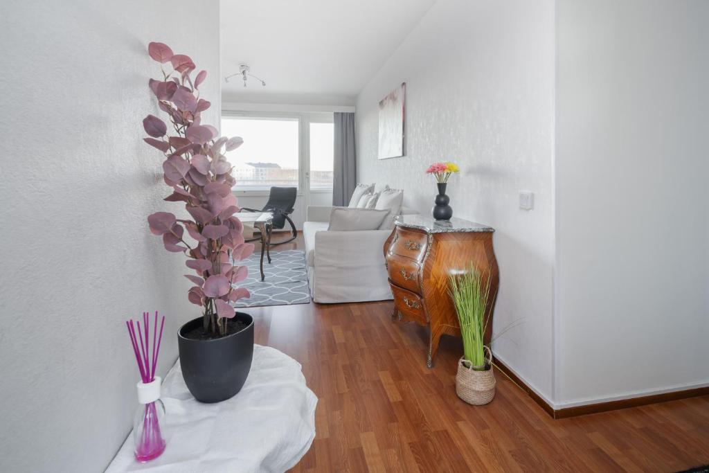una sala de estar con una mesa y flores en una habitación en Sari’s place with nice view en Turku