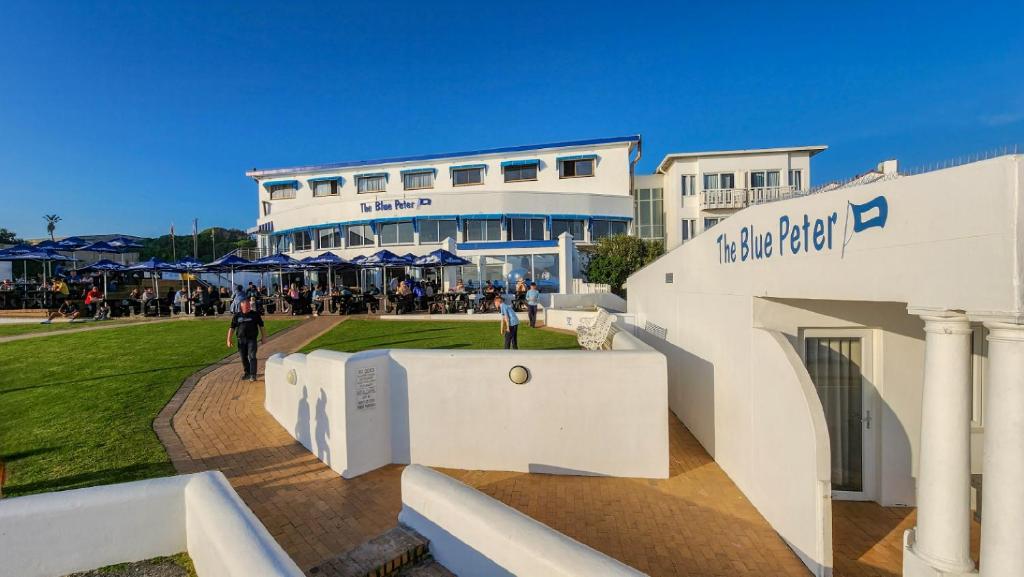 a white building with people standing outside of it at The Blue Peter Hotel in Cape Town