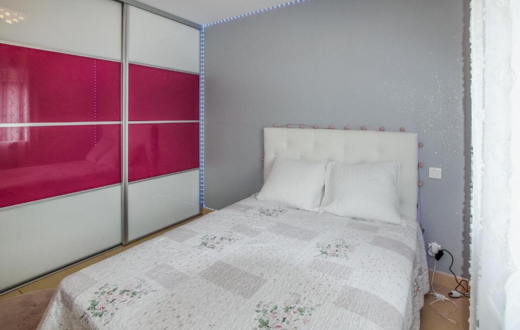 a bedroom with a white bed with a pink window at Beautiful Home In Sauveterre With Private Swimming Pool, Can Be Inside Or Outside in Sauveterre
