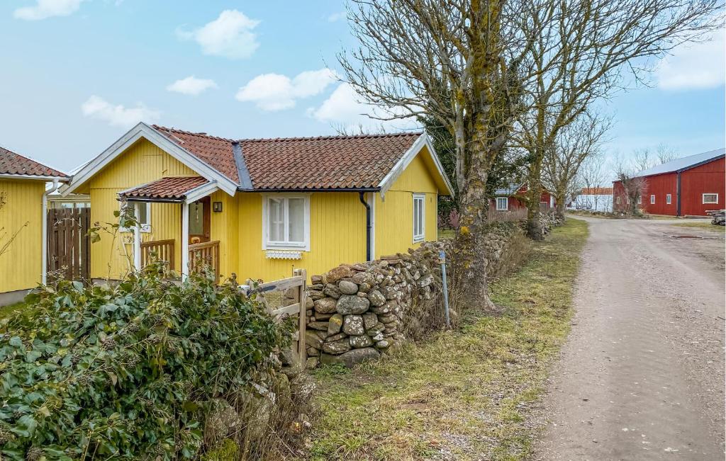 una casa amarilla al lado de un camino de tierra en 2 Bedroom Amazing Home In Borgholm, en Borgholm