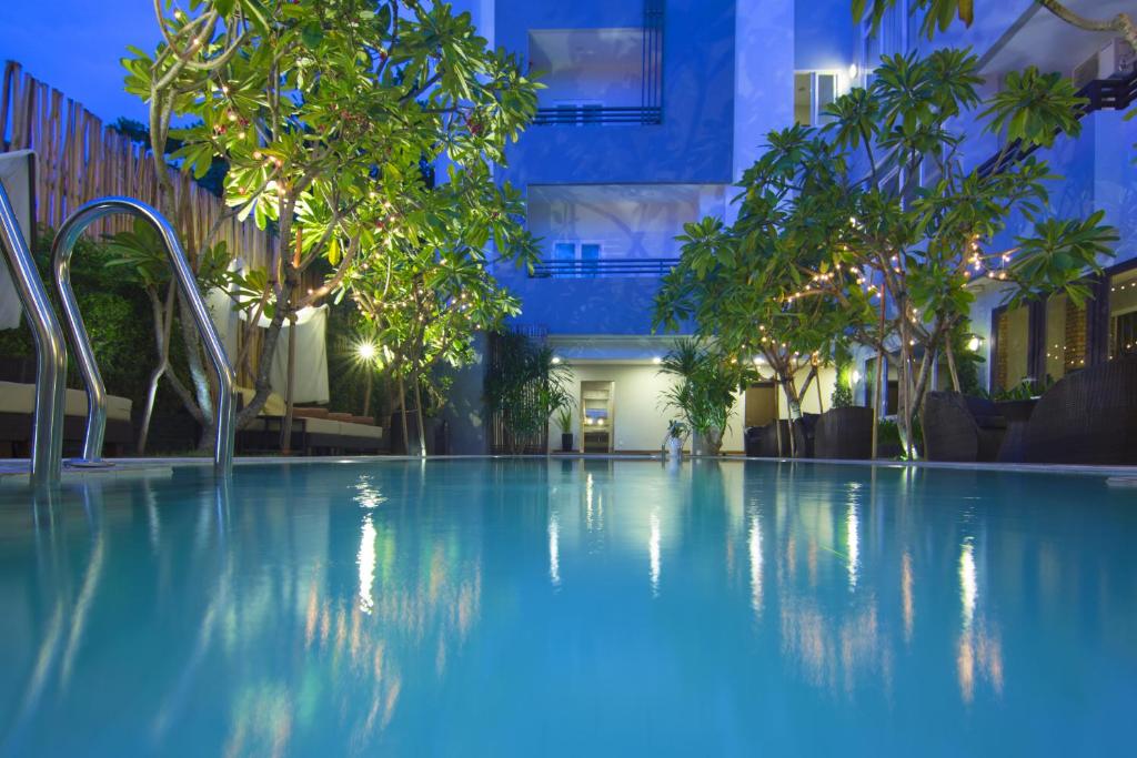 a large swimming pool with trees and a building at Anik Boutique Hotel & Spa on Norodom Blvd in Phnom Penh