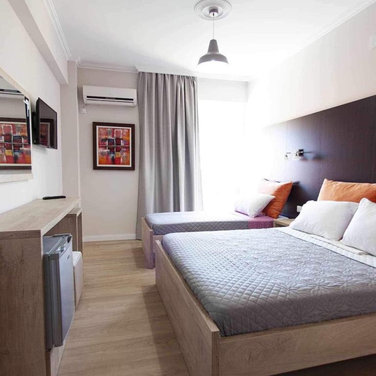 Postel nebo postele na pokoji v ubytování George Hotel Rooms&Suites