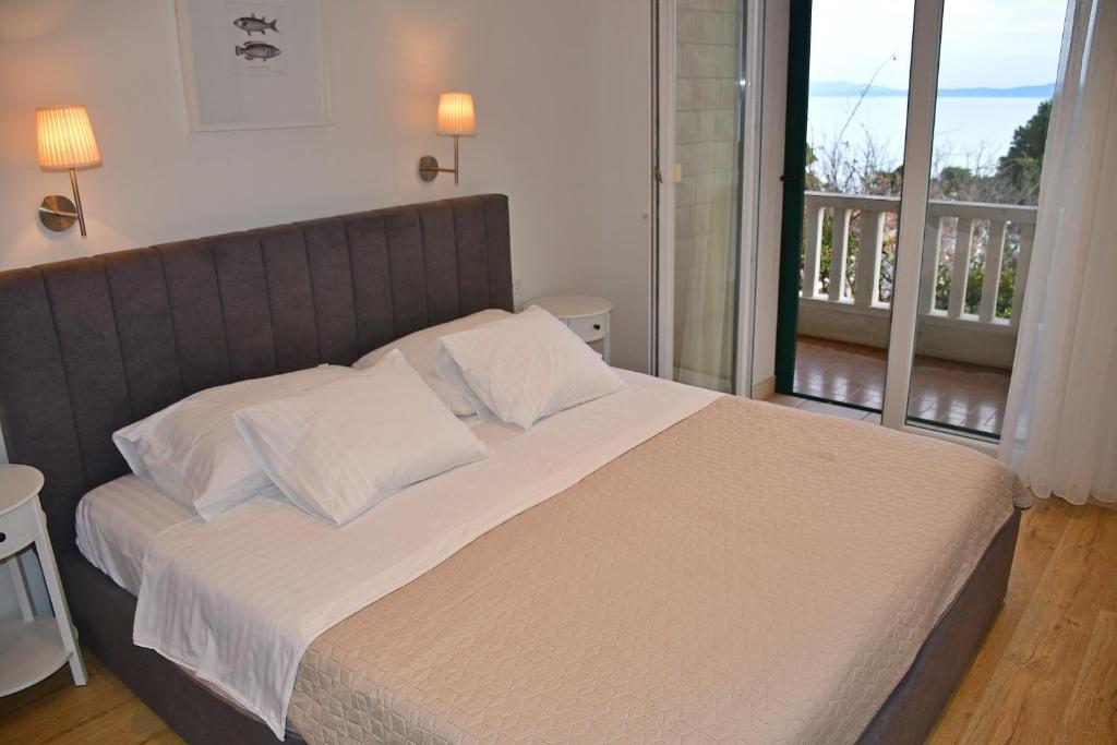 1 dormitorio con 1 cama grande y balcón en Apartment Esperansa, en Brela