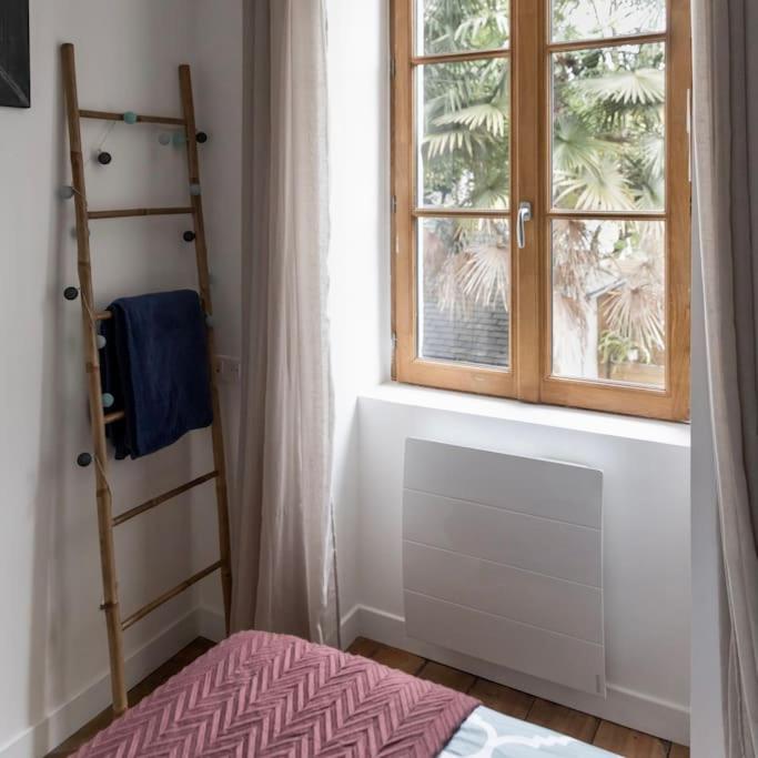 a bedroom with a window and a ladder and a bed at Maison et appartement attenant pour 10 personnes avec terrasse, cour et parking in Pau