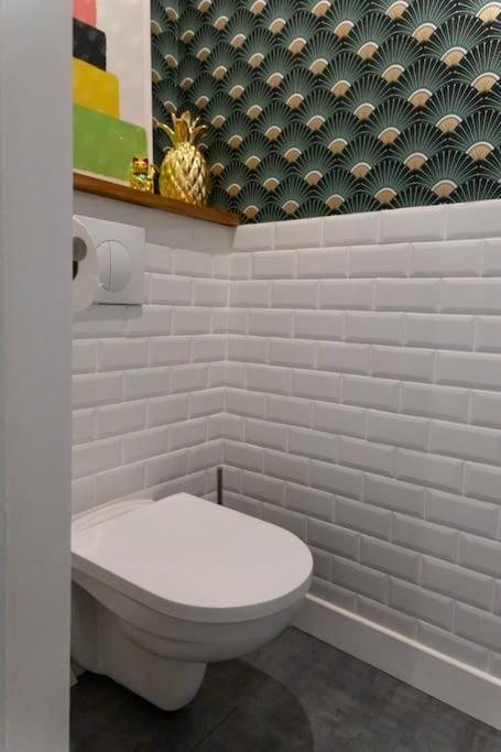 a bathroom with a white toilet in a room at Maison et appartement attenant pour 10 personnes avec terrasse, cour et parking in Pau