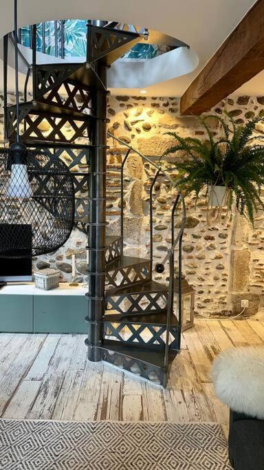 a spiral staircase in a room with a stone wall at Maison et appartement attenant pour 10 personnes avec terrasse, cour et parking in Pau