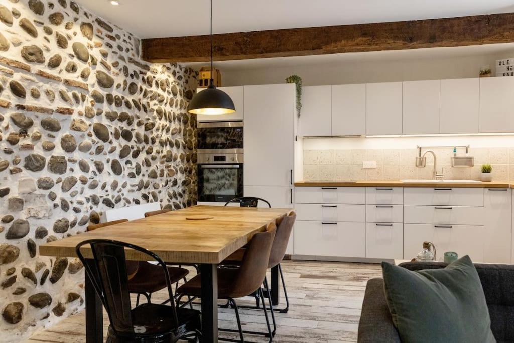 a kitchen and dining room with a wooden table and chairs at Maison et appartement attenant pour 10 personnes avec terrasse, cour et parking in Pau