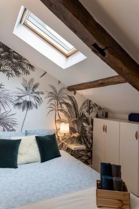 a bedroom with a bed and a skylight at Maison et appartement attenant pour 10 personnes avec terrasse, cour et parking in Pau