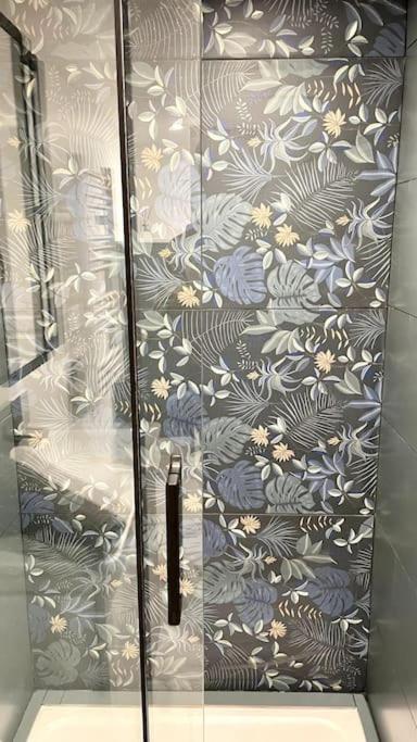 a glass door with a floral pattern on a wall at Maison et appartement attenant pour 10 personnes avec terrasse, cour et parking in Pau