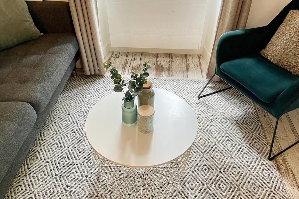 a living room with a couch and a table with flowers at Maison et appartement attenant pour 10 personnes avec terrasse, cour et parking in Pau