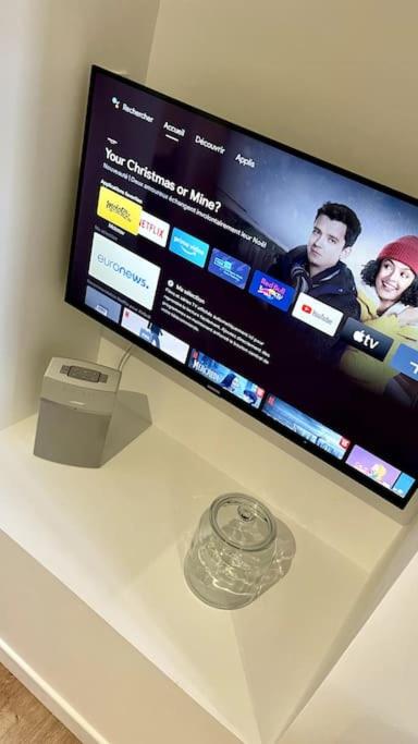 a flat screen tv sitting on top of a table at Maison et appartement attenant pour 10 personnes avec terrasse, cour et parking in Pau