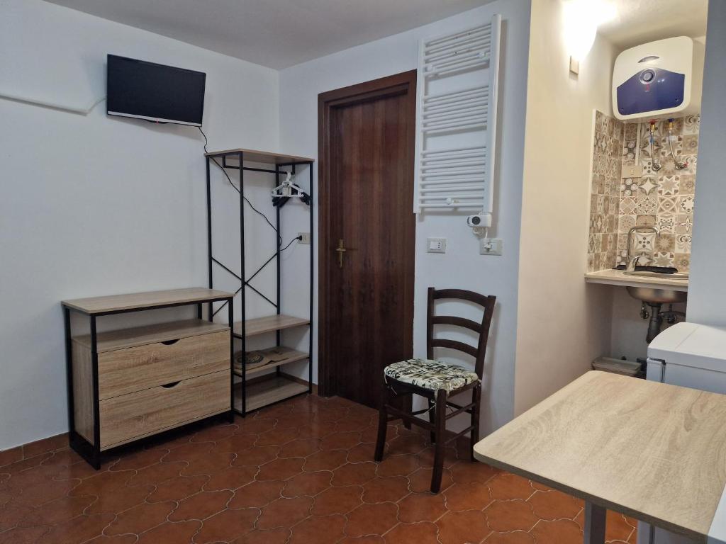 una stanza con tavolo, sedia e armadietto di Vico 2 monolocale ad Albissola Marina