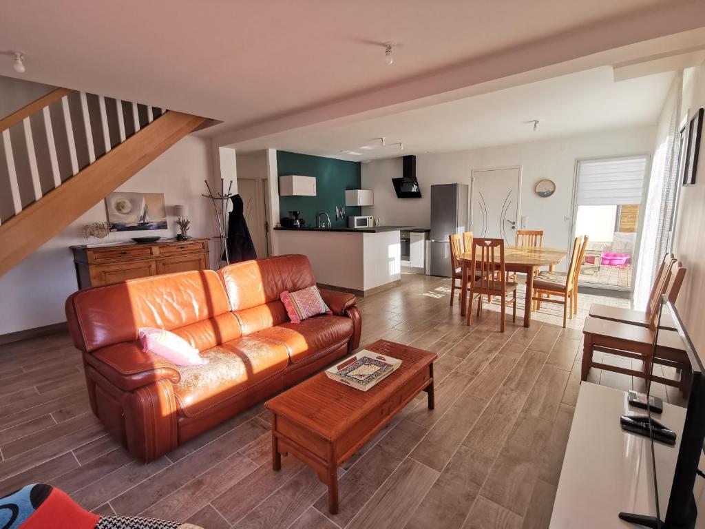 un salon avec un canapé en cuir et une table dans l'établissement Aux portes de Chausey, à Saint-Pair-sur-Mer