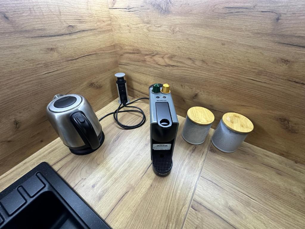 a electronic device on a table next to two cups at Studio magnifique avec terrasse spacieuse Loèche-les-Bains Vacances in Leukerbad