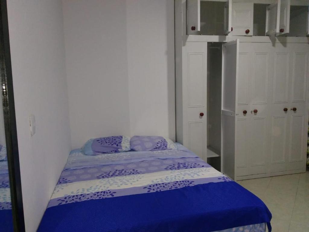a small bedroom with a bed with a blue blanket at usoinmobiliario in Medellín