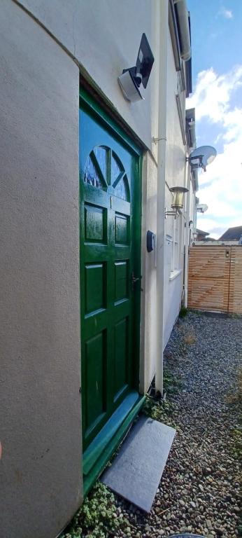 una porta verde sul lato di un edificio di The Court Cottage 2 bedroom a Exeter