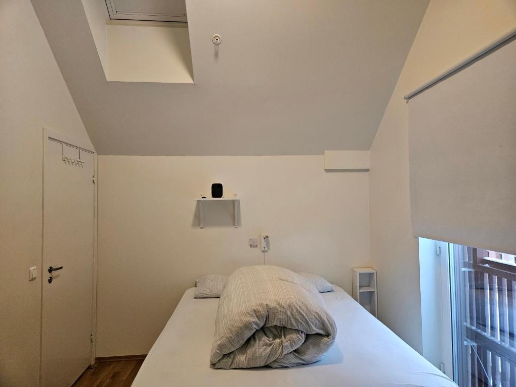 1 dormitorio con cama con almohada en Ny og moderne leilighet, midt i byen1, en Trondheim